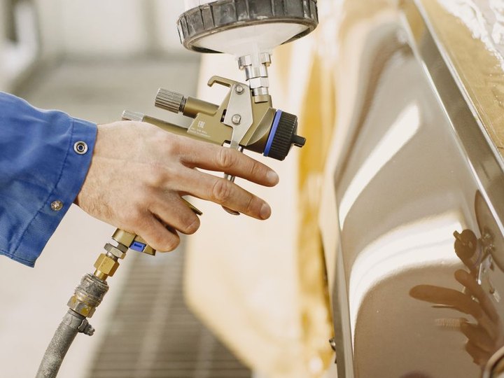 Auto body technician repairing a damaged vehicle panel